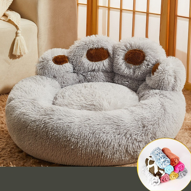 Fluffy gray pet bed with brown accents on a beige couch.
