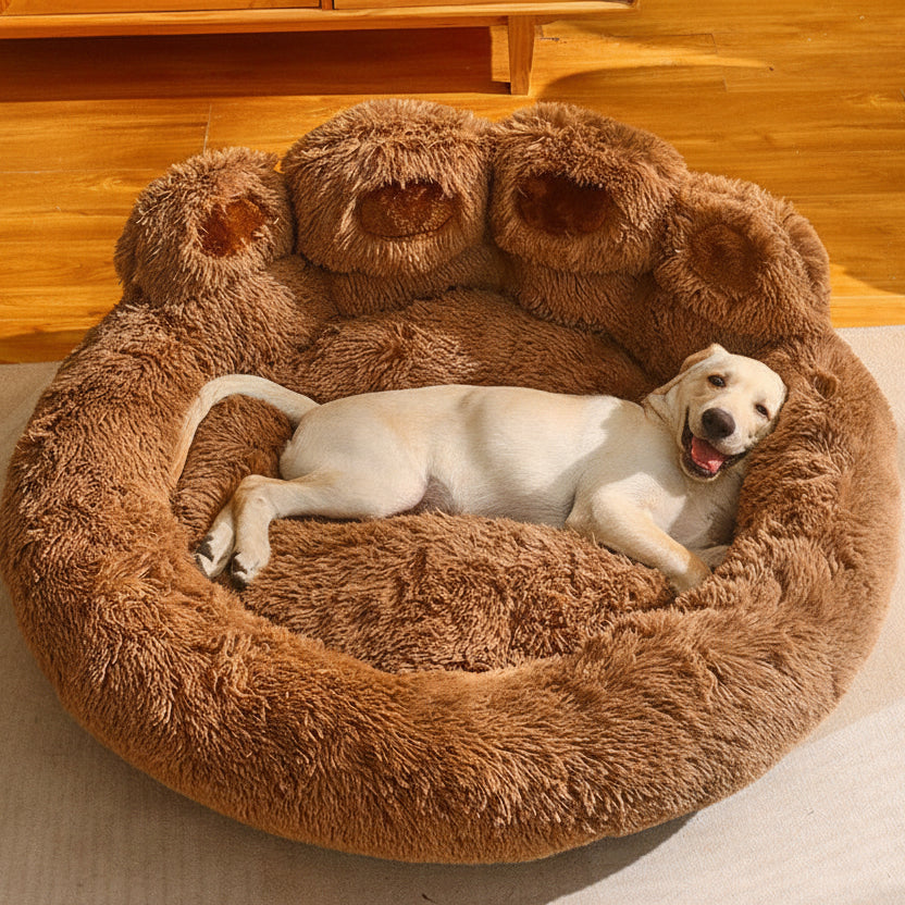 Dog lying on a fluffy brown pet bed in a room with wooden flooring.