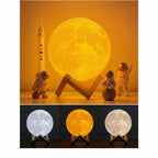 Moon-shaped lamp with three color options displayed on a stand with small astronaut figures.