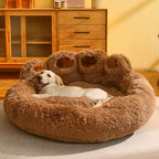 Dog lying on a fluffy brown pet bed in a room with wooden furniture.